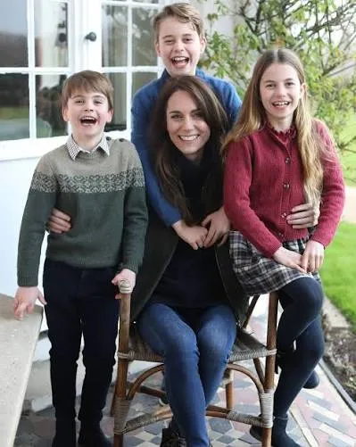 Prince William, Princess Kate, Prince George, Princess Charlotte, and Prince Louis standing together in a green landscape after the Three Peaks Challenge, wearing matching jeans and sneakers.