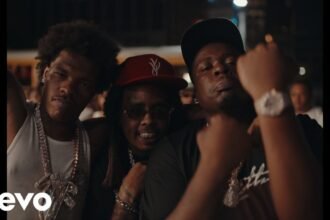 Screenshot of Lil Baby, Bally Baby, and Fatt Smaxk standing beside a vintage car on the Coast 2 Coast music video set.