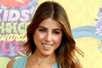 Daniella Monet smiling on a red carpet at a Hollywood event