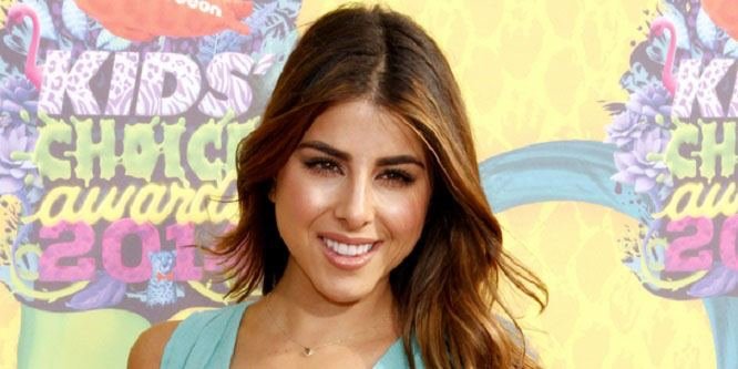 Daniella Monet smiling on a red carpet at a Hollywood event