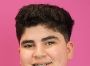 Eric Befumo, a teenage TikTok star known as Big Justice, smiling while holding a Costco food tray