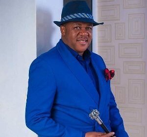 Portrait of Nigerian actor Francis Duru wearing a dark suit, smiling at a film event in Lagos.