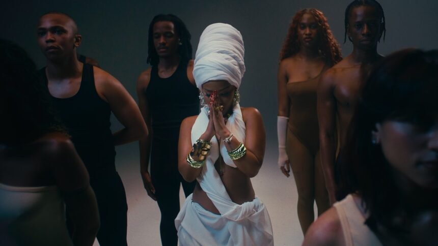Zee Nxumalo, Dlala Thukzin, Funky QLA and TBO performing together on a stage set with bright lights in the Guqa (My Prayer) music video.