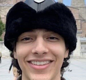 HamzahTheFantastic smiling while filming a TikTok comedy video in a bright room