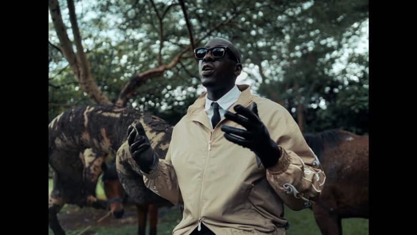 Bien performing in the 'I’ll Be Okay' music video, surrounded by dancers and stylized lighting, captured by cinematographer Dennis Odera.