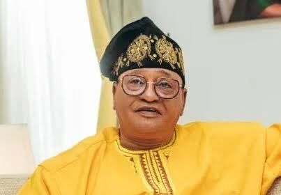Jide Kosoko standing in front of a movie poster, looking thoughtful about the financial loss of his recent film