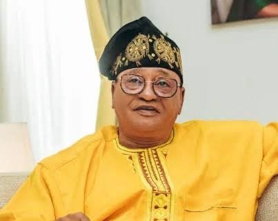 Jide Kosoko standing in front of a movie poster, looking thoughtful about the financial loss of his recent film