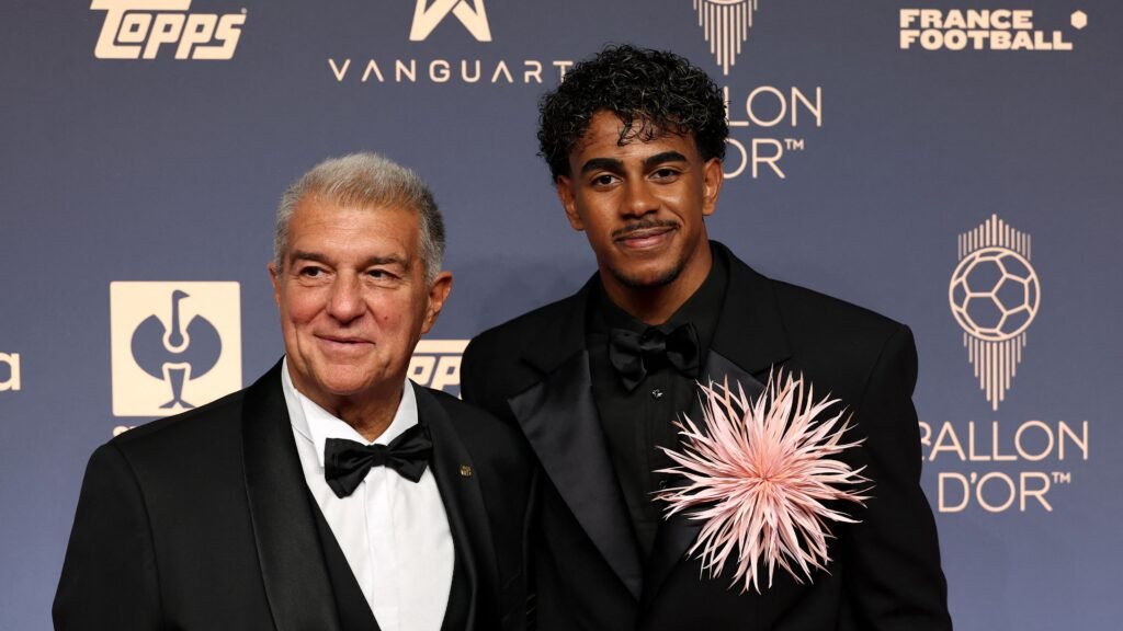 Lamine Yamal, wearing a Barcelona jersey, holding the Kopa Trophy during the Ballon d'Or ceremony in London