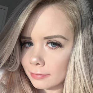 Mackenzie Turner smiling while holding a phone, showcasing her TikTok and Roblox content.