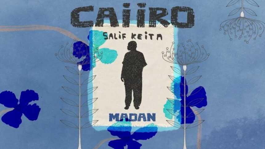 Salif Keita singing on stage, with the cover art for the Caiiro Remix of 'Madan' displayed.