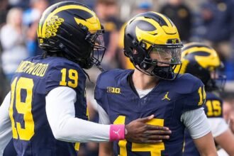 Michigan quarterback Tommy Carr (14) embraces Bryce Underwood (19) on the field before the Michigan vs Indiana game at Michigan Stadium, Ann Arbor, Oct. 24, 2026.