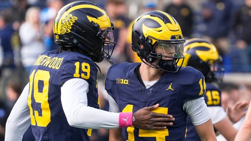 Michigan quarterback Tommy Carr (14) embraces Bryce Underwood (19) on the field before the Michigan vs Indiana game at Michigan Stadium, Ann Arbor, Oct. 24, 2026.