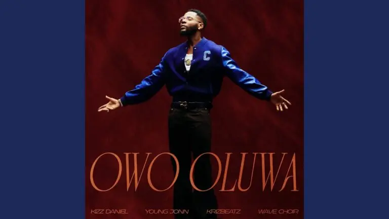 Kizz Daniel on stage singing Owo Oluwa with Young Jonn, Krizbeatz and the Wave Choir, bright lights in the background