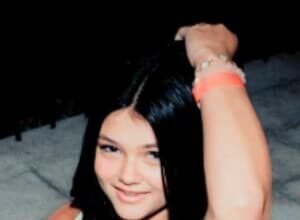 Stella Harvey, a young TikTok star from Charlotte, North Carolina, smiling while holding a smartphone during a video shoot.