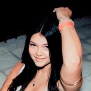 Stella Harvey, a young TikTok star from Charlotte, North Carolina, smiling while holding a smartphone during a video shoot.