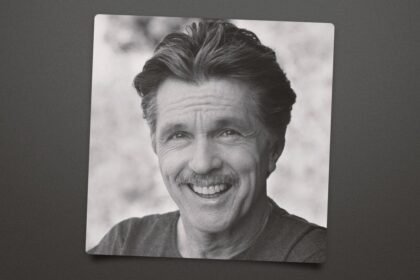 Tom Skerritt wearing a rugged jacket, standing on a film set with a serious expression.