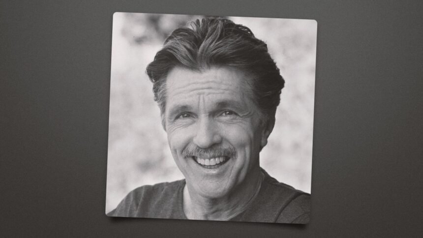 Tom Skerritt wearing a rugged jacket, standing on a film set with a serious expression.