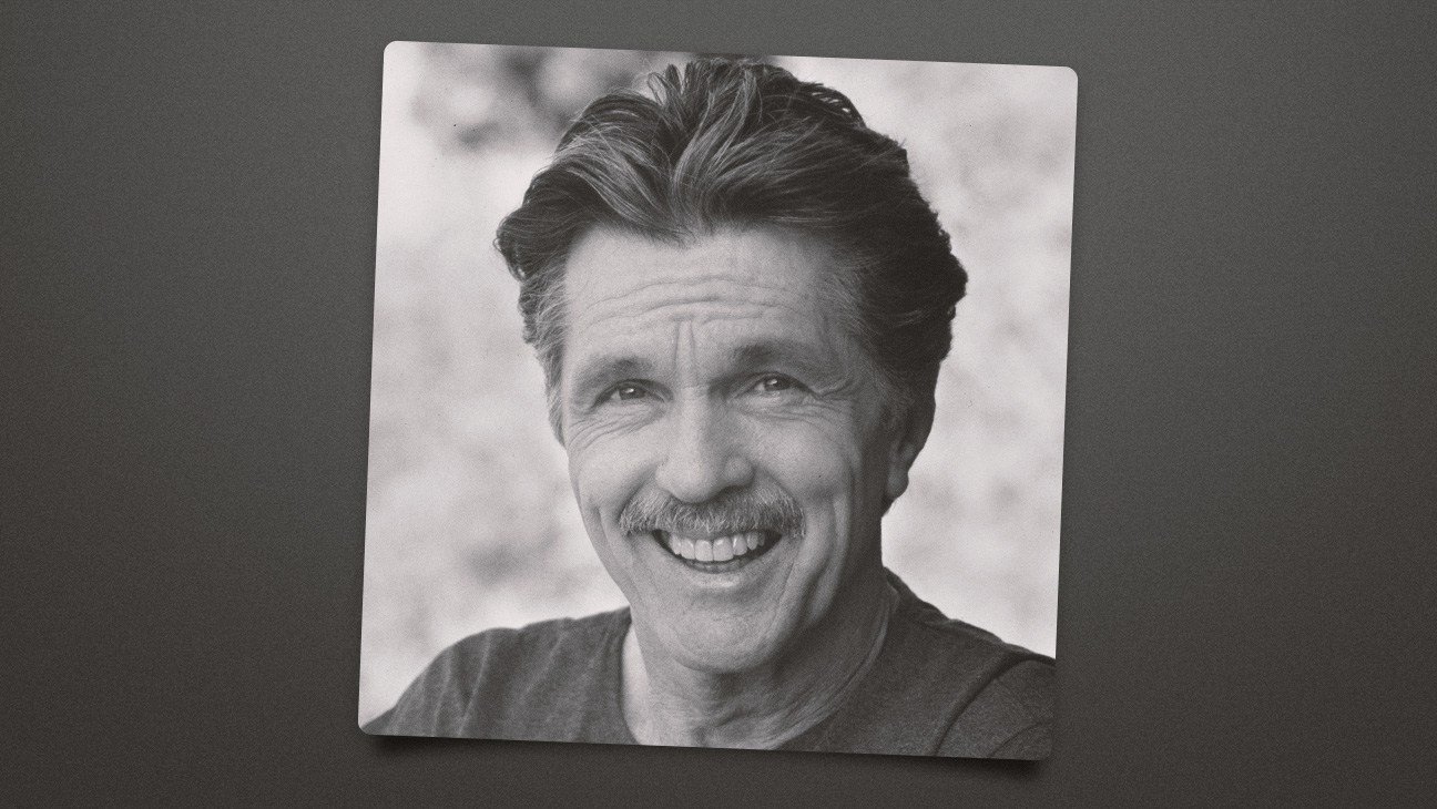 Tom Skerritt wearing a rugged jacket, standing on a film set with a serious expression.
